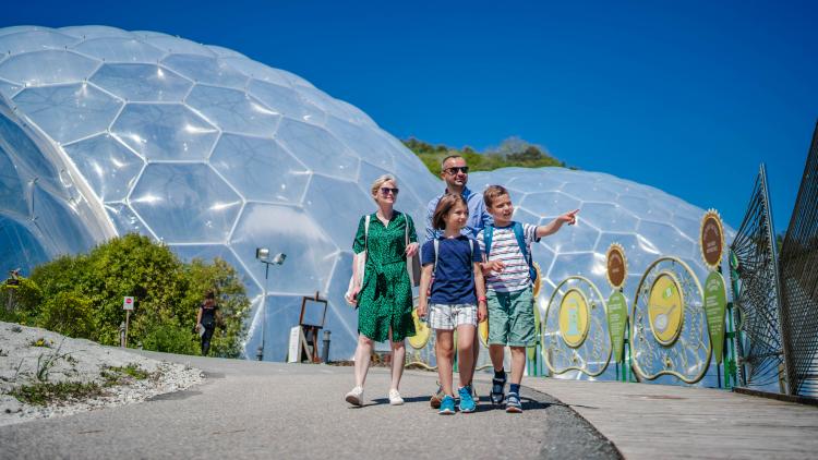 Family walking towards the camera away from the Eden Project Biomes