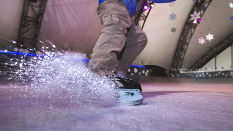 Up close shot of ice skates on ice rink